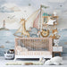 A cozy nursery featuring a watercolor animal sailor mural on the wall behind a wooden crib with soft neutral bedding.