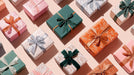 A pattern of gift boxes in forest green, burnt orange, and blush pink with fine botanical line art and ribbon bows