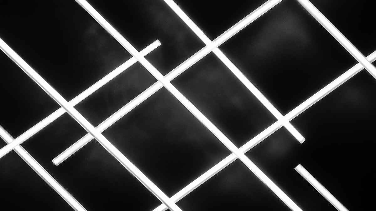Abstract wallpaper pattern featuring thin glowing white lines intersecting in a grid on a dark charcoal background.