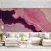 Modern living room with a pink and plum abstract fluid art accent wall behind a white sofa