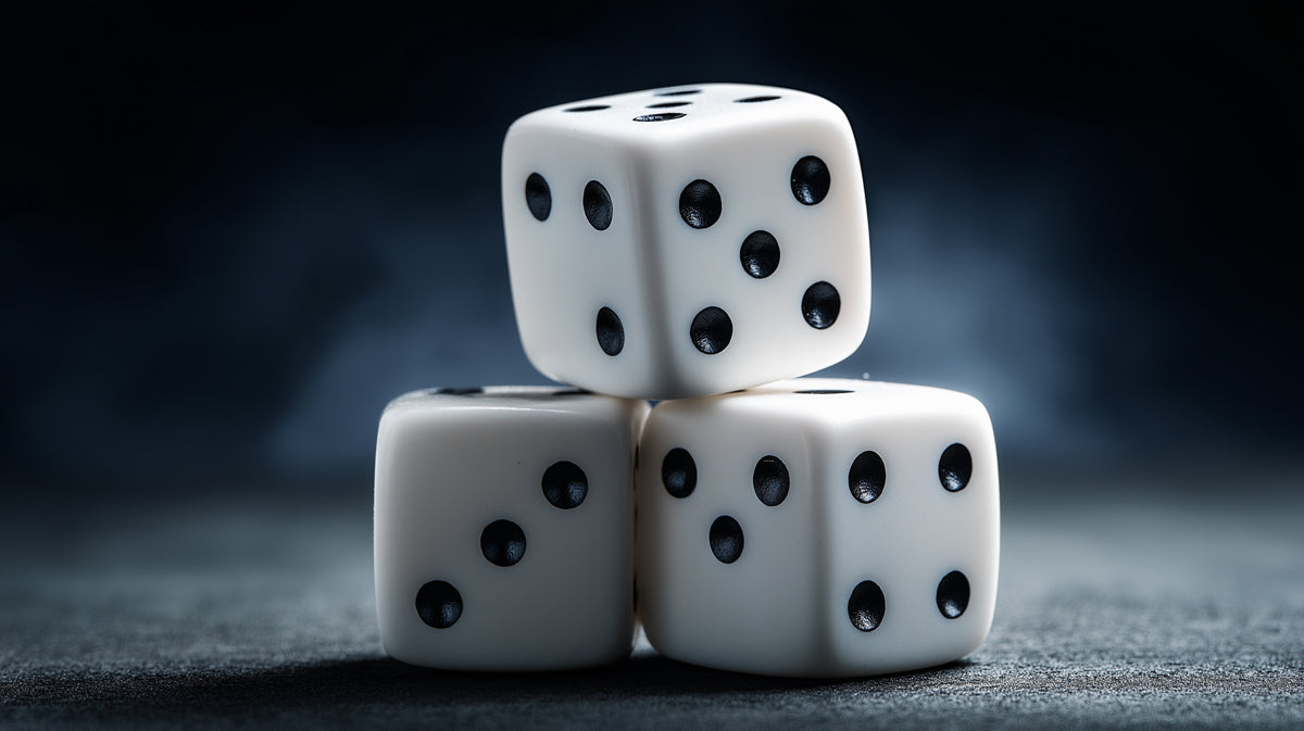 Three white dice stacked on a dark, moody charcoal surface