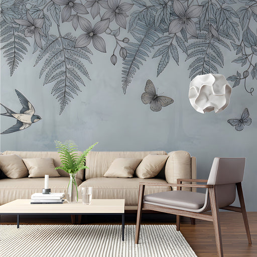 A serene living room with a blue botanical bird and fern mural wallpaper behind a white wooden bed frame