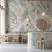 Calm cafe space with muted watercolor foliage wallpaper and white furniture