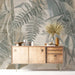 A cozy bedroom with a botanical sage and beige mural behind a neutral upholstered bed.