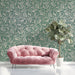 Sophisticated entryway featuring damask fern wallpaper behind a mahogany desk