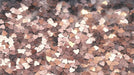 Close-up of confetti heart pattern in shades of rose gold, mocha, and cream