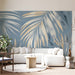 Living room featuring watercolor palm leaf mural behind a beige sofa
