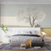 Bedroom wall featuring a minimalist landscape wallpaper with soft earth tones and a centered tree.