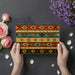 A home office workspace with the tribal pattern wallpaper creating a textured backdrop for a solid wood desk.