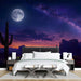 A sophisticated bedroom interior showcasing a starry night landscape wallpaper.