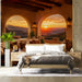 A desert canyon mural covering a bedroom wall with terracotta decor and natural sunlight.