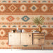 Cozy bedroom interior with a geometric desert-inspired mural behind a linen headboard and rustic wooden accents
