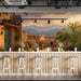A cozy bar featuring a desert sunset wall mural behind a leather sofa and rustic wood decor.