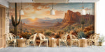 A spacious cafe featuring the desert sunset wallpaper as a floor-to-ceiling focal point behind a neutral sofa.