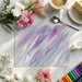 Fluid art wallpaper featured on a focal wall in a bright home office with light wood furniture.