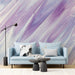 Abstract blue and purple wall mural shown in a cozy reading nook with velvet seating.