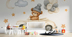 Nursery room featuring a playful teddy bear wall mural behind a wooden crib