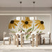 A bright sun-filled meeting room with a floral yellow mural on the main wall above a wooden table.