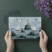 A bright bathroom featuring seaside mural wallpaper with soft blue tones and sailboat motifs.