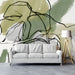 A serene study feature wall with soft sage and black line art wallpaper behind a neutral upholstered bed.