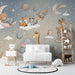 Nursery room featuring a dreamy space-themed wall mural with woodland creatures and floating stars.