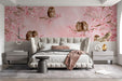 A whimsical nursery room with an owl and cherry blossom mural behind a white wooden crib.