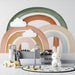 Calm bedroom design with earthy rainbow arch wallpaper as a soft headboard backdrop