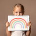 A cozy playroom with a stippled rainbow wall mural and soft floor cushions for children.