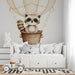 A charming bedroom corner highlighting the raccoon mural, accessorized with warm lighting and a soft reading chair.