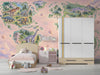 A cozy nursery room featuring a dinosaur world map wallpaper on a feature wall behind a wooden crib.