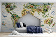 Embroidered world map mural installed in a cozy bedroom with wooden crib