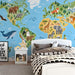 A bright bedroom wall showcasing a detailed animal world map mural behind a modern wooden desk.