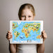 Educational animal map wallpaper in a bright kid's playroom with colorful activity furniture