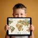 A cozy kid’s bedroom featuring a world map animal mural behind a white bed frame.
