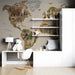 World wildlife map wallpaper in a home study room featuring natural wood furniture and indoor plants.
