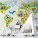 A creative home school or playroom space with a vibrant world map wallpaper mural covering the main feature wall.
