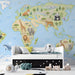 World map mural installed in a colorful nursery with wooden crib and toys