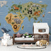A cozy bedroom featuring the world map mural behind a wooden crib with soft bedding.