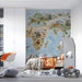 A bright bedroom interior with an educational world map wallpaper featuring various wildlife and nature motifs.
