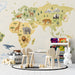 A nursery room wall decorated with a soft-toned world map mural with safari animals and natural accents.