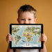 A cozy home office study room with an illustrated world map wall mural as a decorative, intellectual backdrop.
