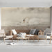 A serene living room setting featuring a swan mural on the headboard wall with linen bedding.
