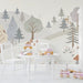 Charming nature wall mural in a bright playroom filled with soft textures and pillows.