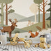 A cozy nursery featuring a woodland paper-cut mural with friendly animals and soft earthy colors.