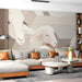 A cozy living room featuring a soft neutral sheep mural on the primary wall with light wooden furniture