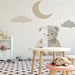 A serene playroom corner with the bear and moon wall mural, paired with a comfortable armchair and warm lighting.