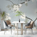 A quiet dining room featuring subtle floral wall mural with white blossoms.