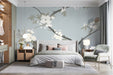 Floral bedroom mural wallpaper featuring delicate ink-wash cherry blossoms behind a light oak bed.