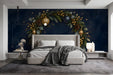 A festive bedroom with a deep navy wreath mural behind a dark wood table, set for a holiday dinner with brass accents.