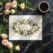 The winter botanical wreath wallpaper installed in a bright guest bedroom above a neutral headboard.